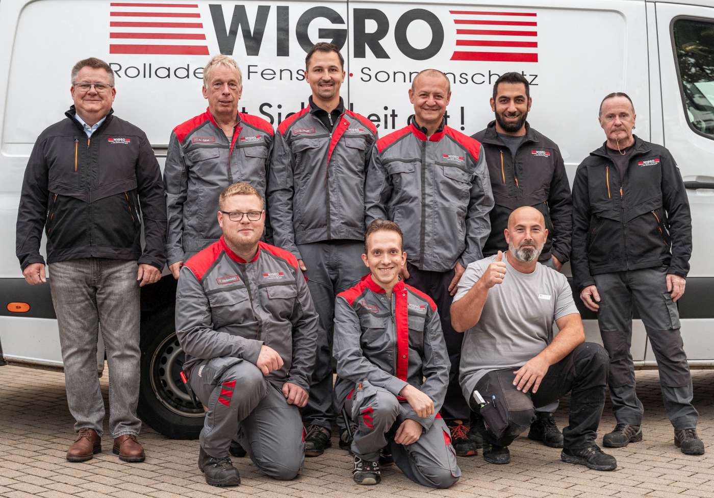 Das Wigro Team Bamberg. Neun Personen stehen vor dem Firmentransporter.