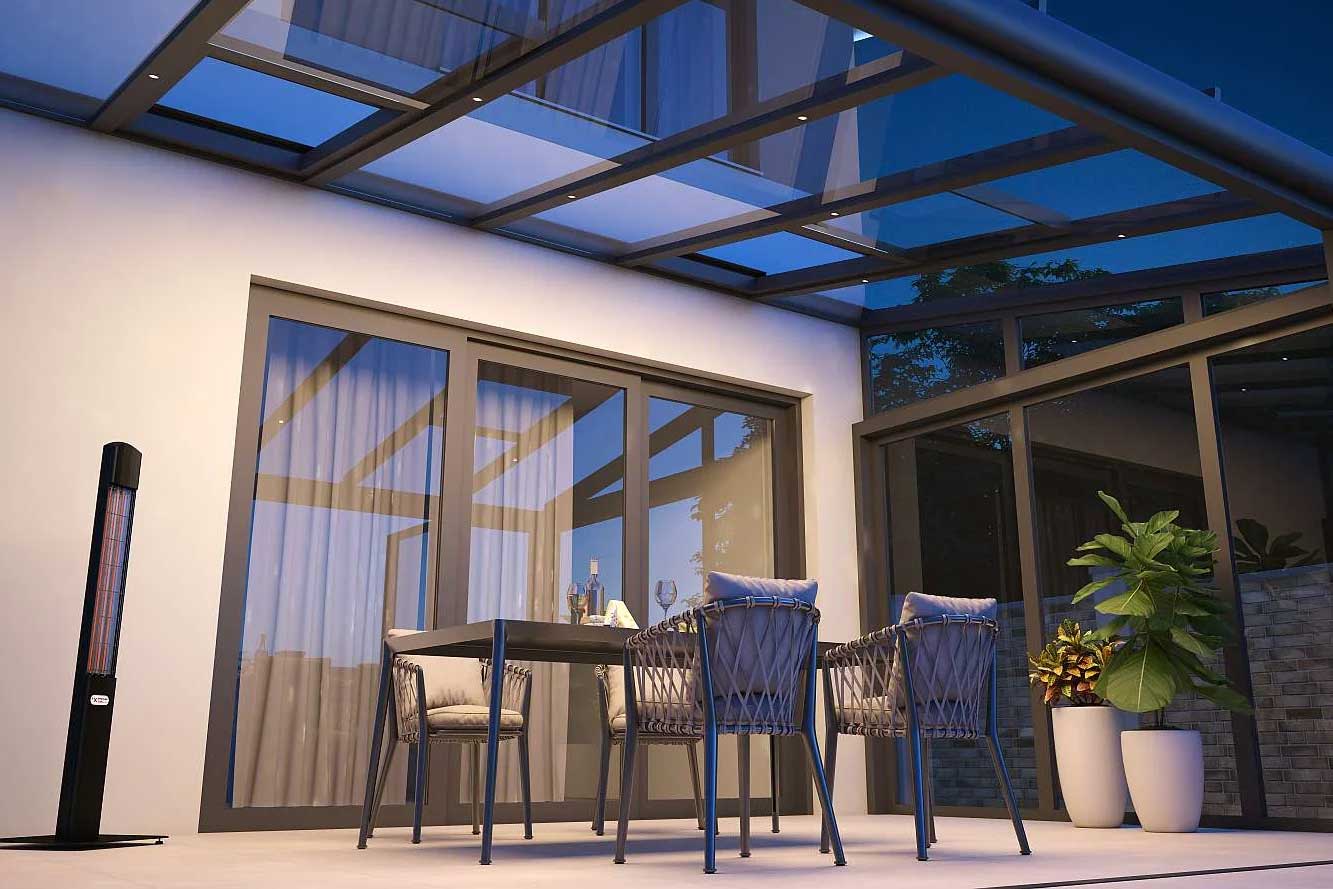 Ein Terrassendach bei Dunkelheit mit LED Beleuchtung und einer Sitzgruppe, zwei Pflanzen und einen Heat Tower.