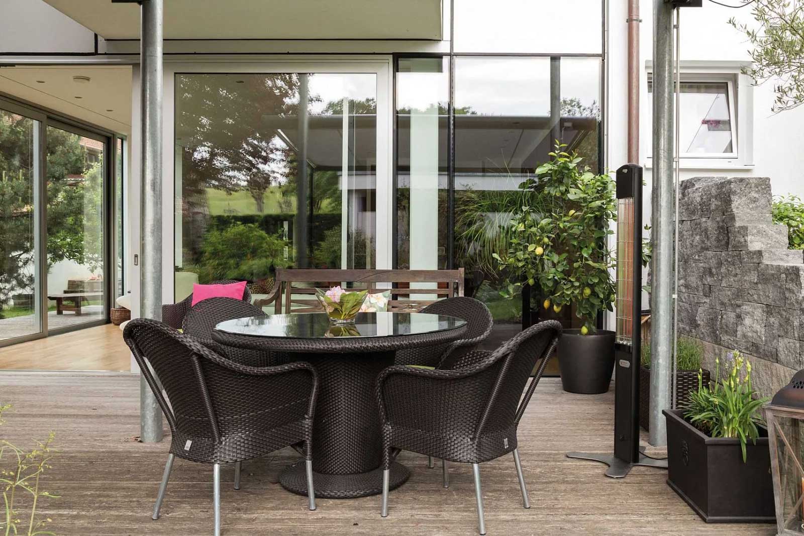 Ein Heat Tower neben einer Sitzgruppe unter einer Terrassenüberdachung in Amberg.