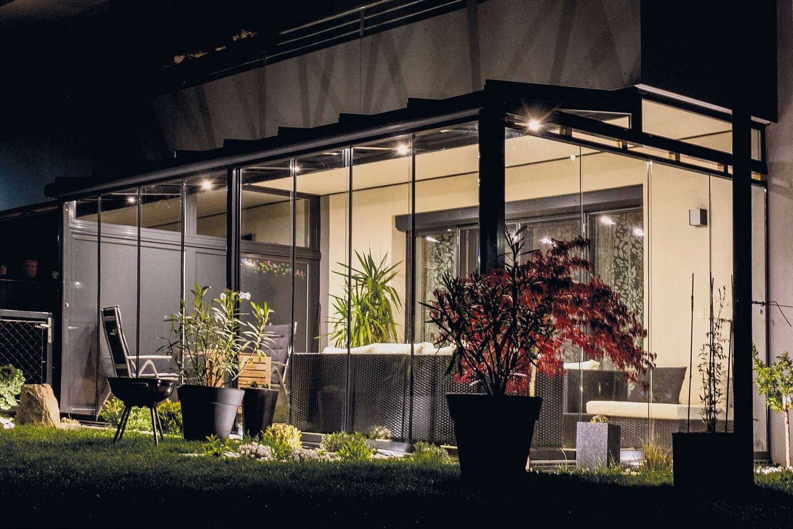 Eine Terrassenüberdachung mit LED Beleuchtung bei Nacht.